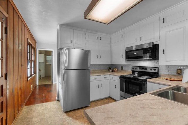 kitchen with sink, white cabinets, tasteful backsplash, and stainless steel appliances