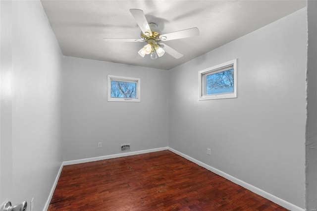 spare room with dark wood-type flooring, ceiling fan, and plenty of natural light