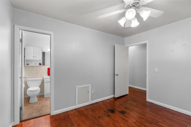 unfurnished bedroom with ceiling fan, dark hardwood / wood-style flooring, and ensuite bath