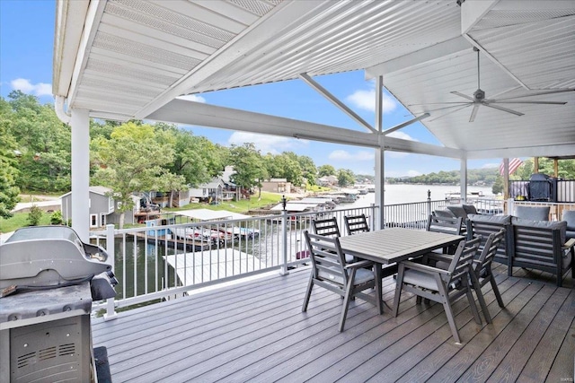 wooden terrace with a water view, area for grilling, and ceiling fan