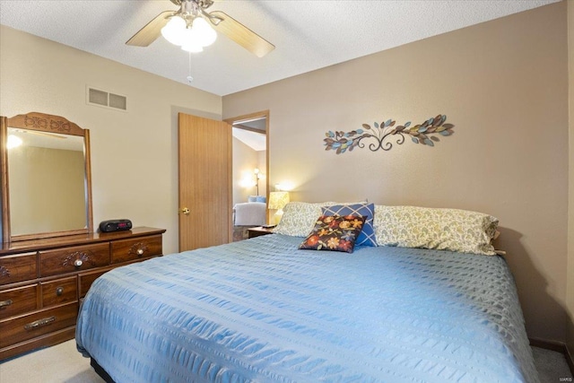 bedroom with a textured ceiling, ceiling fan, and carpet