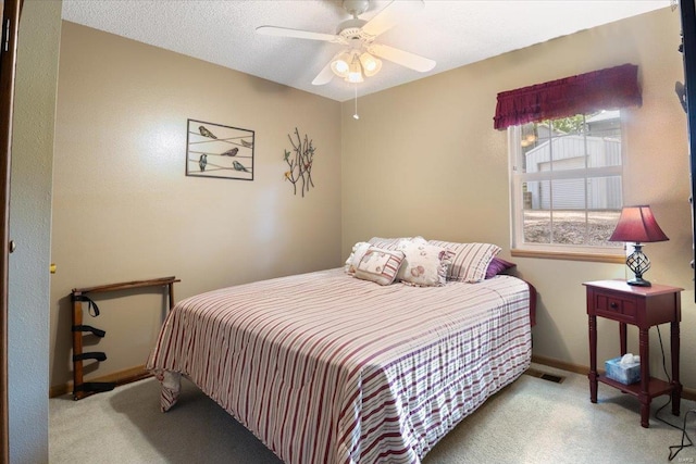 carpeted bedroom featuring a textured ceiling and ceiling fan