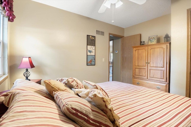 bedroom featuring ceiling fan and a textured ceiling