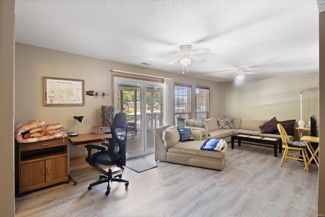 office space featuring ceiling fan, light hardwood / wood-style floors, and a textured ceiling