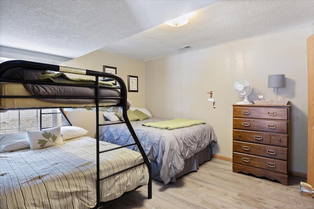 bedroom featuring a textured ceiling and light hardwood / wood-style floors