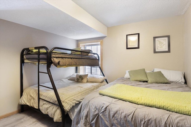 bedroom with a textured ceiling and light wood-type flooring