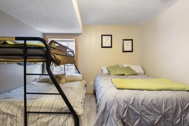 bedroom with hardwood / wood-style floors and a textured ceiling