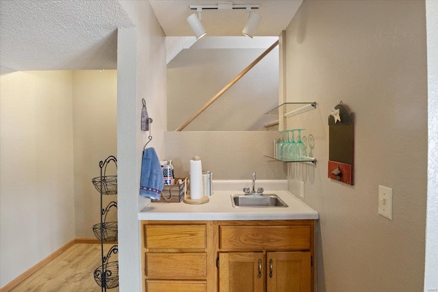 bathroom featuring sink, wood-type flooring, and a textured ceiling