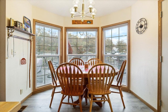 dining space with a chandelier, light hardwood / wood-style flooring, and a wealth of natural light