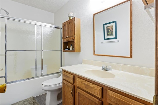 full bathroom with vanity, toilet, enclosed tub / shower combo, and a textured ceiling