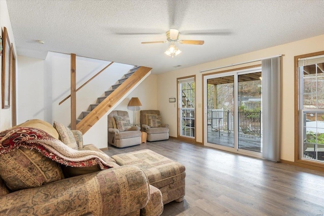 living room with ceiling fan, hardwood / wood-style floors, and a textured ceiling