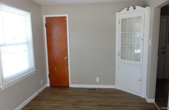 unfurnished room featuring visible vents, baseboards, and wood finished floors