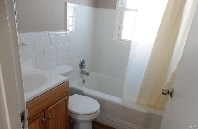 bathroom featuring vanity, shower / bath combination with curtain, and toilet