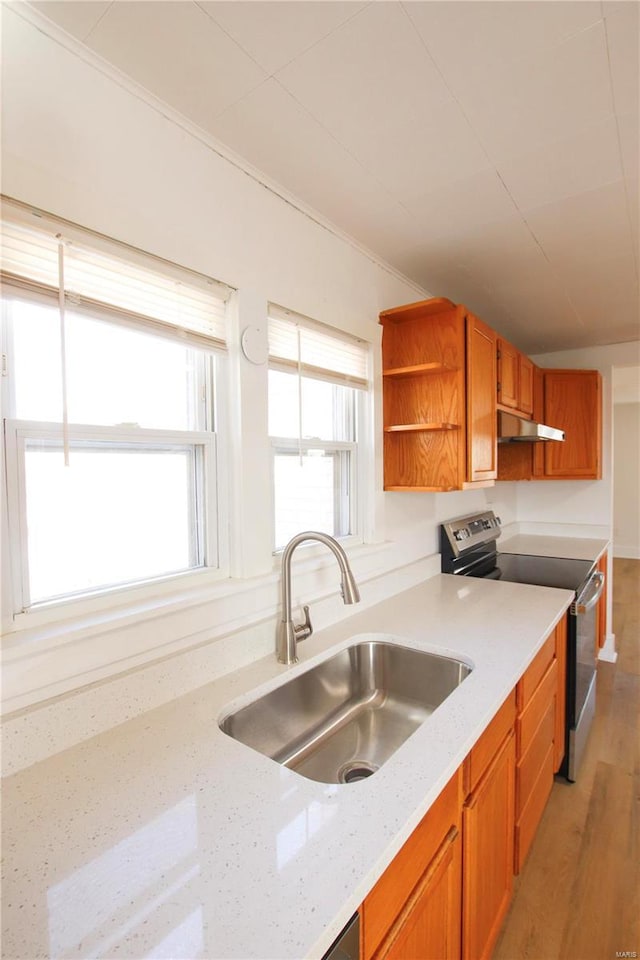 kitchen featuring stainless steel electric stove, light hardwood / wood-style flooring, sink, light stone counters, and ornamental molding