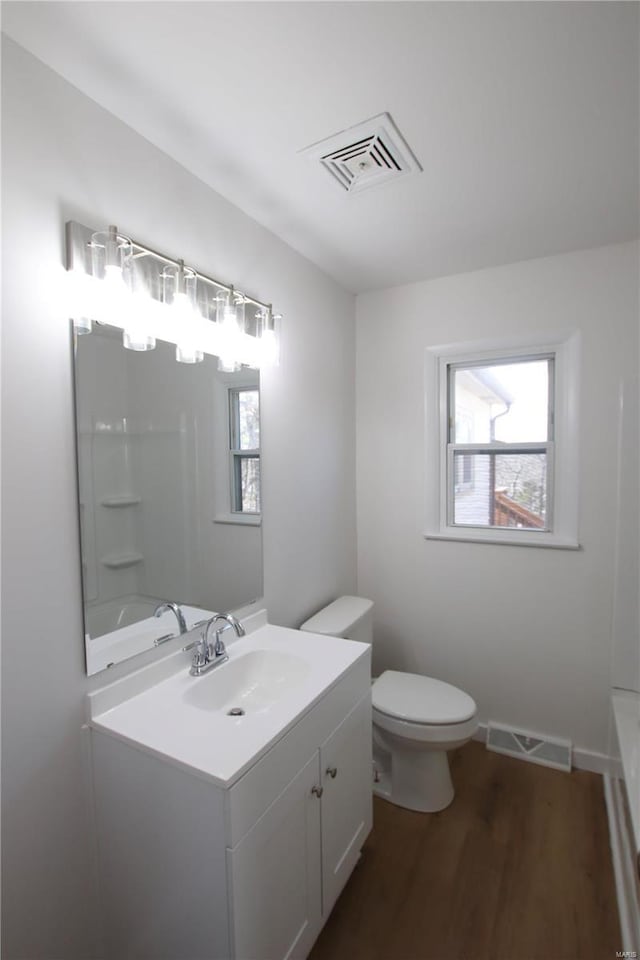 full bathroom with vanity, toilet, a wealth of natural light, and hardwood / wood-style floors