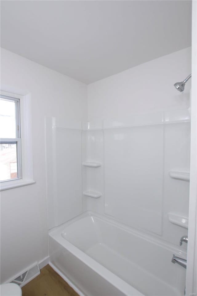 bathroom with hardwood / wood-style flooring and shower / bath combination