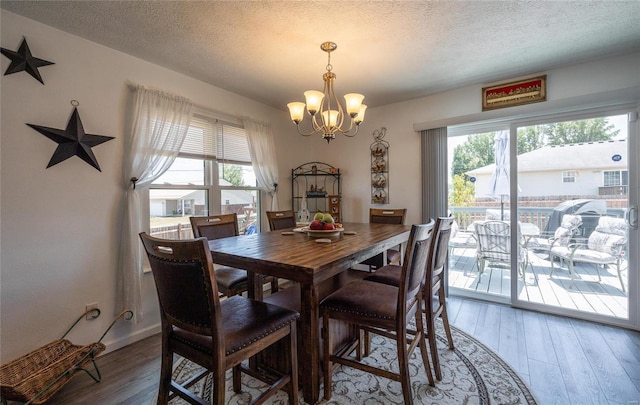 dining room with hardwood / wood-style floors, a chandelier, and a textured ceiling