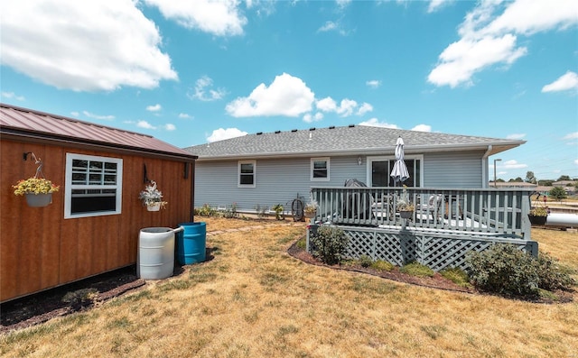 back of house with an outbuilding, a yard, and a deck