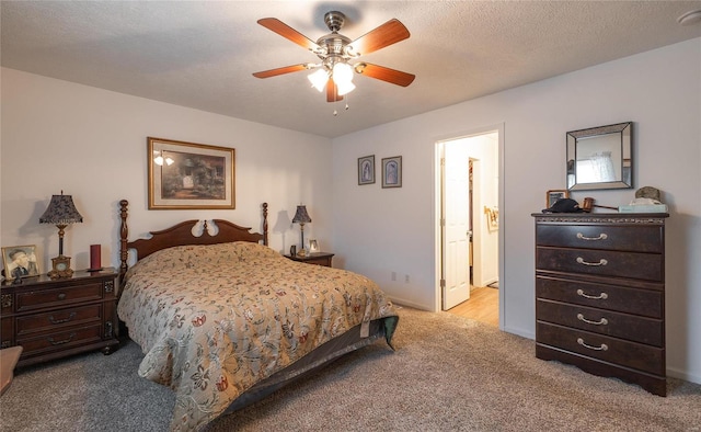 bedroom featuring ceiling fan, a textured ceiling, light carpet, and connected bathroom