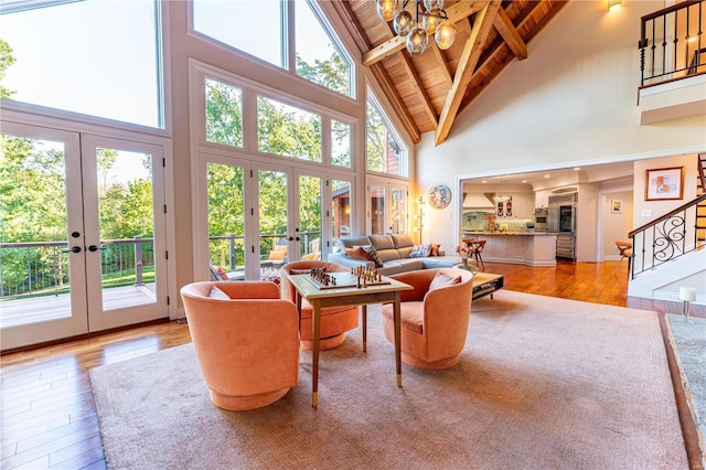 living room with high vaulted ceiling, french doors, wooden ceiling, beam ceiling, and light hardwood / wood-style flooring