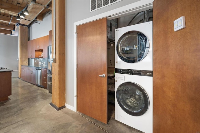 clothes washing area featuring stacked washer and dryer