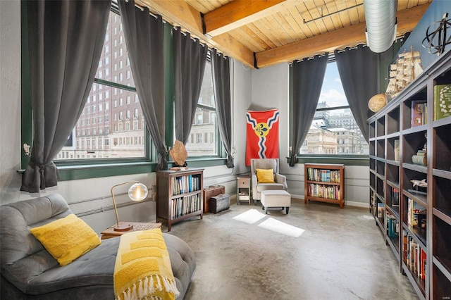 sitting room featuring wood ceiling, beamed ceiling, and concrete flooring