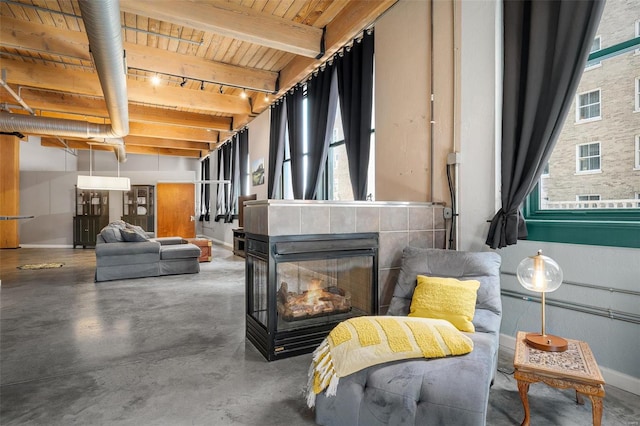 interior space with concrete floors, plenty of natural light, beam ceiling, and wood ceiling