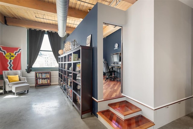 living area featuring concrete floors, beamed ceiling, and wood ceiling