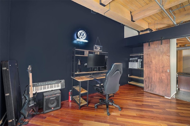 home office with hardwood / wood-style flooring, wood ceiling, beamed ceiling, and a barn door