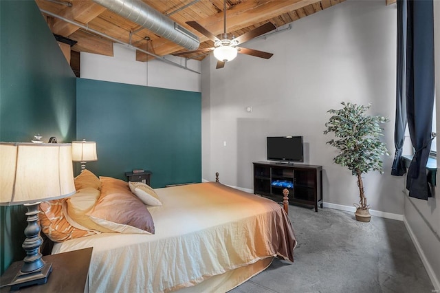 bedroom with ceiling fan, a high ceiling, beamed ceiling, and concrete flooring