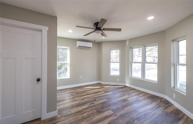 spare room featuring ceiling fan, a wall mounted air conditioner, and dark hardwood / wood-style flooring