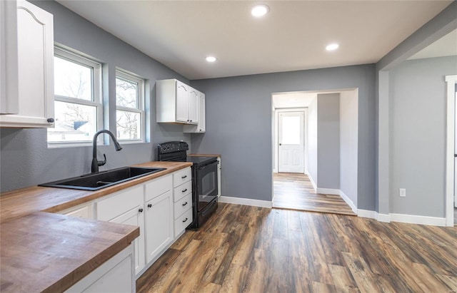 kitchen with white cabinetry, black electric range, sink, and wooden counters