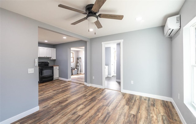 unfurnished living room featuring dark hardwood / wood-style floors, a wall mounted air conditioner, and ceiling fan