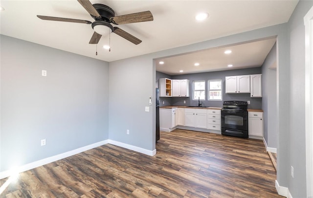 kitchen with dark hardwood / wood-style floors, sink, white cabinets, ceiling fan, and black range with electric cooktop