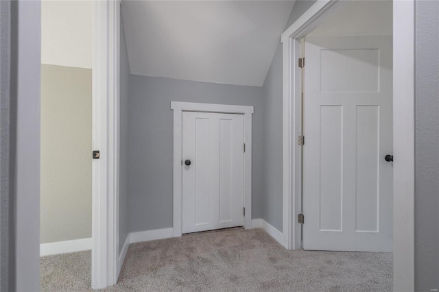 interior space featuring vaulted ceiling and light colored carpet