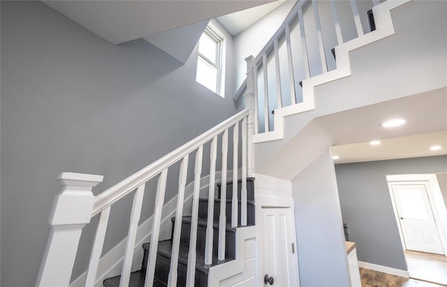 stairs with a high ceiling, baseboards, and recessed lighting