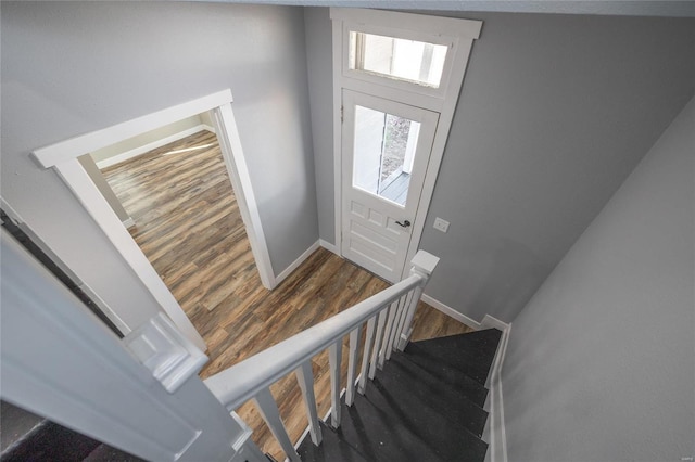 staircase with wood finished floors and baseboards