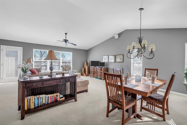 carpeted dining room with ceiling fan with notable chandelier and vaulted ceiling