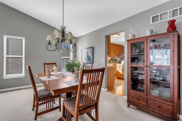 carpeted dining area featuring lofted ceiling and a notable chandelier