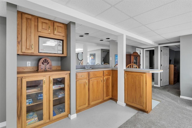 bar featuring sink, a drop ceiling, and light carpet