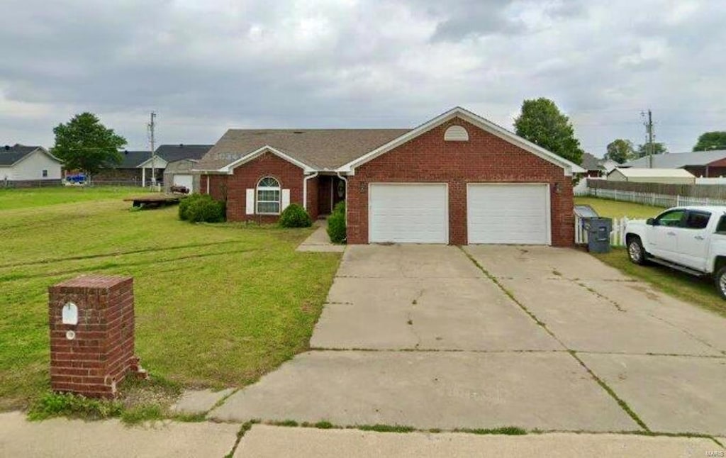 single story home featuring a garage and a front lawn