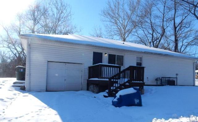 view of snow covered rear of property