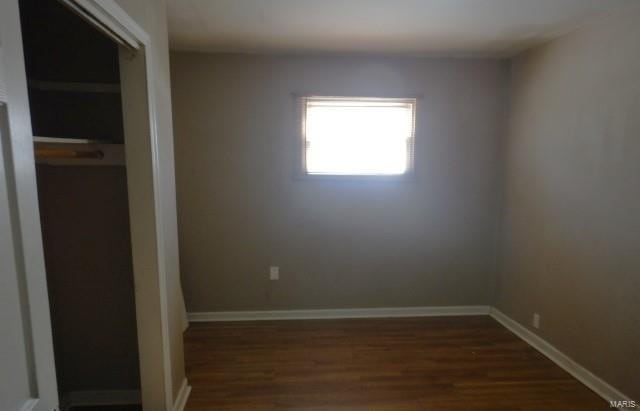 unfurnished room with dark wood-type flooring