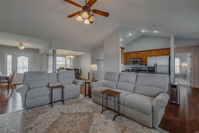 living room with ceiling fan with notable chandelier, ornate columns, light hardwood / wood-style floors, and lofted ceiling