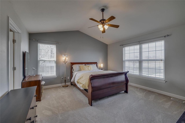 bedroom with ceiling fan, vaulted ceiling, light carpet, and multiple windows