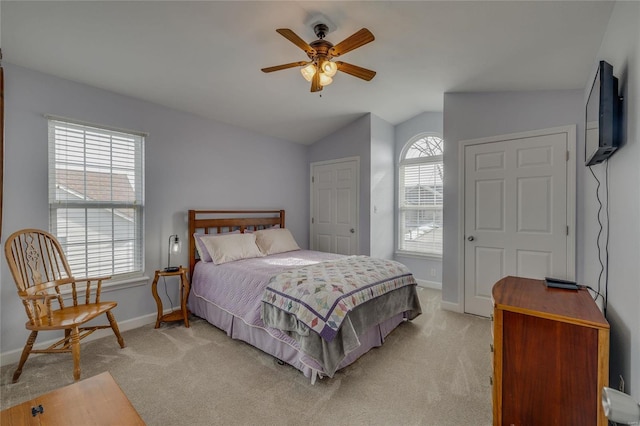 bedroom featuring light colored carpet, vaulted ceiling, and ceiling fan