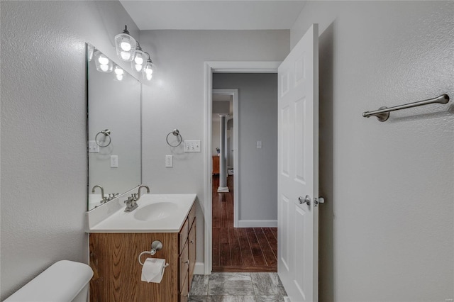 bathroom with wood-type flooring, toilet, and vanity