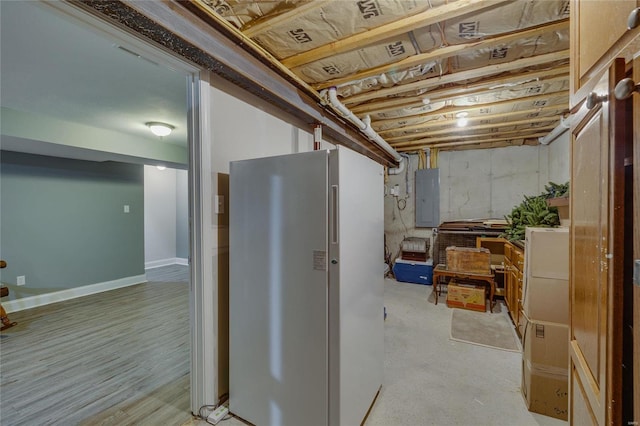 basement featuring electric panel and fridge