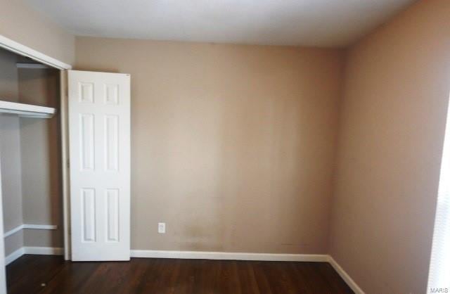 unfurnished bedroom featuring dark hardwood / wood-style floors and a closet