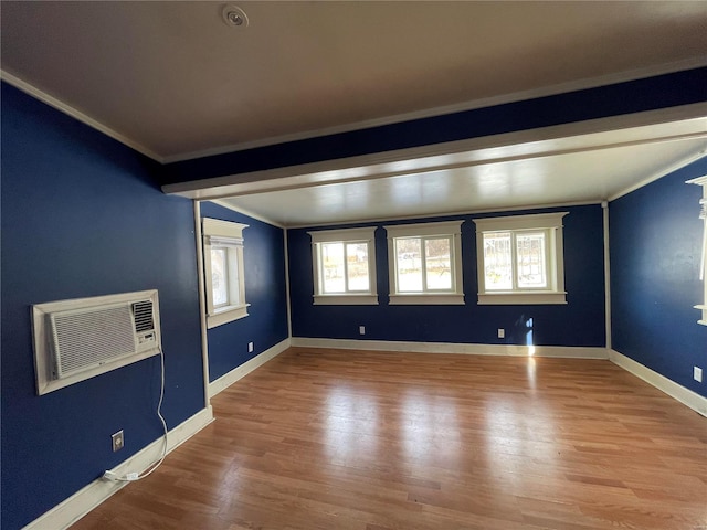 spare room featuring hardwood / wood-style floors, crown molding, and a wall mounted AC